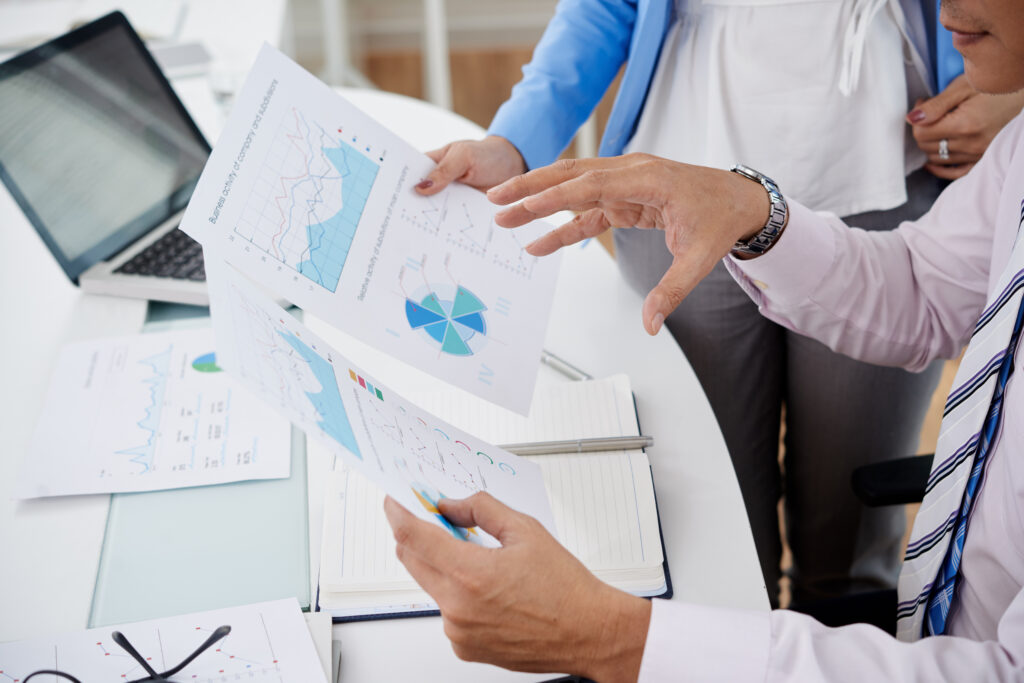 Business professionals analyzing medical billing charts and graphs at a desk, emphasizing operational efficiency and revenue optimization in healthcare practice management.